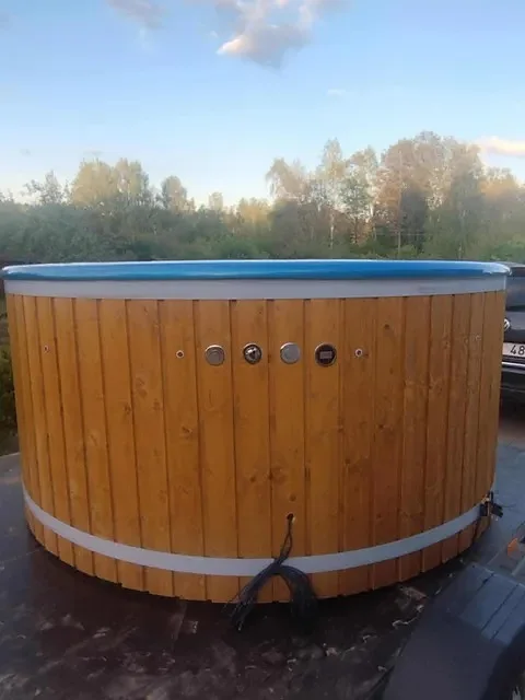 Natural spruce tub with blue interior at sunset
